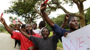 Roman Catholic priest Frank Bwalya (in red) and supporters hold red cards to display their displeasure with the government as they attend a rally in front of the National Assembly, in Lusaka, Zambia, March 22, 2011.
